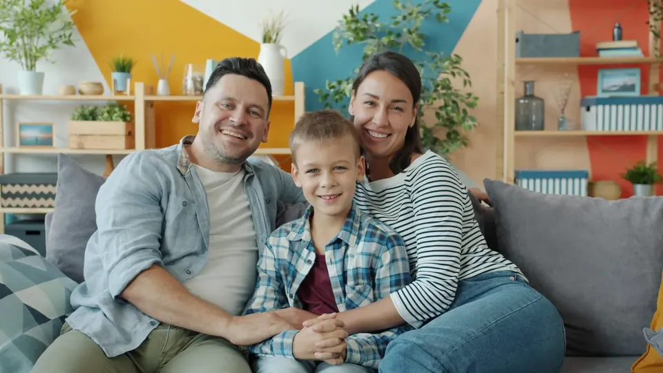 Família feliz em frente à sua casa